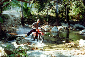 Beim durchfahren von einem kleinen Fluss in Thailand mit dem gemieteten Motorrad einer Enduro über die Insel Koh Samui.