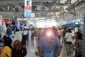 Passagiere in der Abflughalle vom Suvarnabhumi Airport in Bangkok. Der Eingang befindet sich auf dem Bild rechts. Links sind ein paar Zugänge zu den Fluggesellschaften durch die man gehen muss sobald man Airberlin, Condor oder die von Ihnen gebuchte Gesellschaft finden.