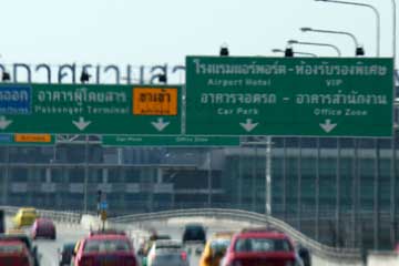 Zubringer zum Suvarnabhumi Airport in Bangkok, Thailand. Mit dem Auto muss man auf die Spur wechseln die auf der grünen Anzeigetafel über der Straße angezeigt wird um zum Beispiel zum Terminal zu gelangen.