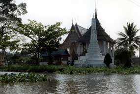 Ein Tempel am Ufer von einem Klong in Bangkok auf dem Weg zu den schwimmenden Märkten.