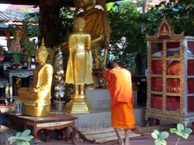 Ein Thai Junge bei der Erledigung einer seiner vom Mönch gestellten Aufgaben in einem buddhistischen Kloster.