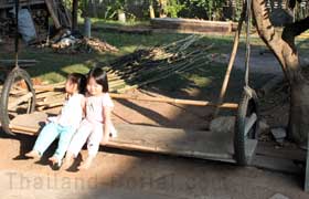 Kinder auf einer selbst gebauten Hollywood-Schaukel in Thailand.